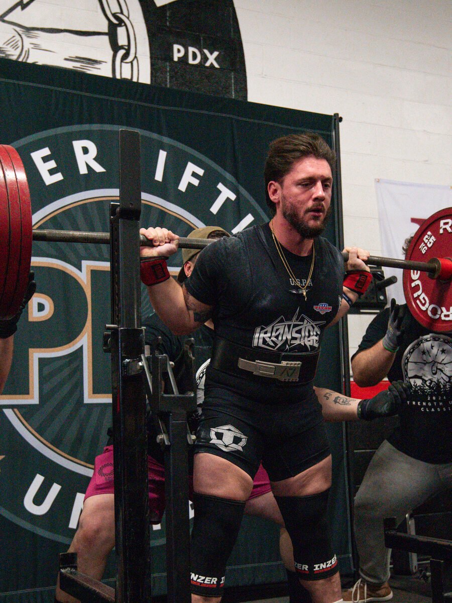 An athlete coached by Ardell unracking a competition squat